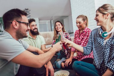 Bir grup mutlu genç arkadaş evde bira içip eğleniyorlar.