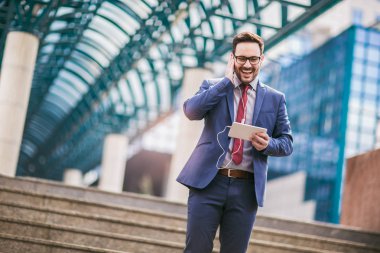 Yürüyüş ve iş binada dijital tablet kullanarak iş adamı. 