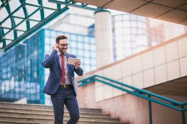 Yürüyüş ve iş binada dijital tablet kullanarak iş adamı. 