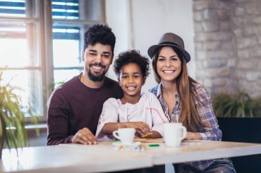 Anne ve baba ile kızı çizim. Kız ve karışık yarış veliler evde eğlenmek.