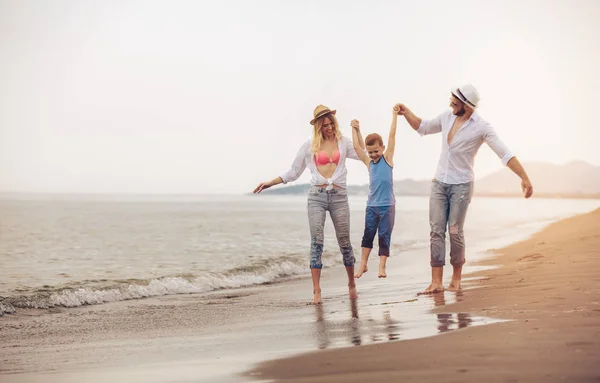 快乐的年轻家庭在海滩上玩的开心 奔跑和跳跃 — 图库照片