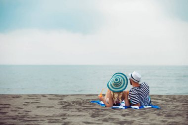 Mutlu genç çift sahilde yalan ve kokteyl içme