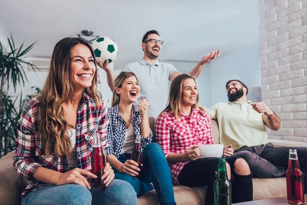 Mutlu arkadaşlar ya da futbol taraftarları televizyonda maç izleyip zaferi evde kutluyorlar. Dostluk, spor ve eğlence kavramı..