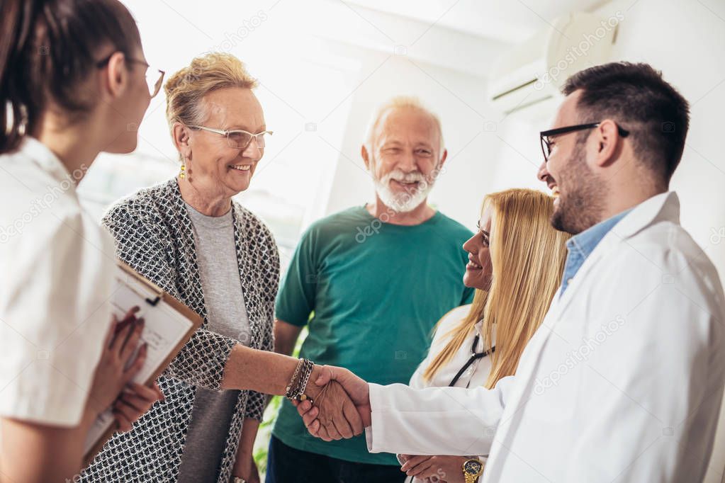 Group of young doctor during home visit senior people