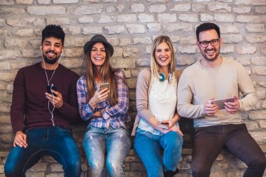 Çeşitlilik öğrencilerin arkadaş dijital cihazlar genel kavram istimal, tuğla duvar arka plan.