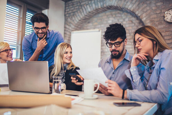  Group of young business people in smart casual wear working together in creative office
