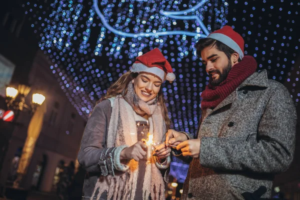 Jong liefhebbend paar branden sterren door vakantie verlichting op — Stockfoto