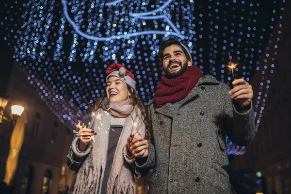 Jong liefhebbend paar branden sterren door vakantie verlichting op — Stockfoto