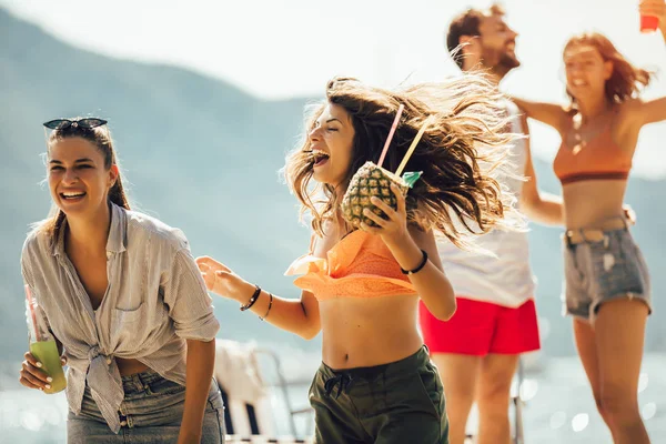 Szczęśliwi młodzi ludzie tańczą na plaży i dobrze się bawią. — Zdjęcie stockowe