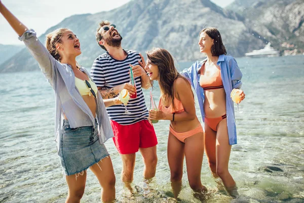 Amigos felices divirtiéndose en la playa — Foto de Stock