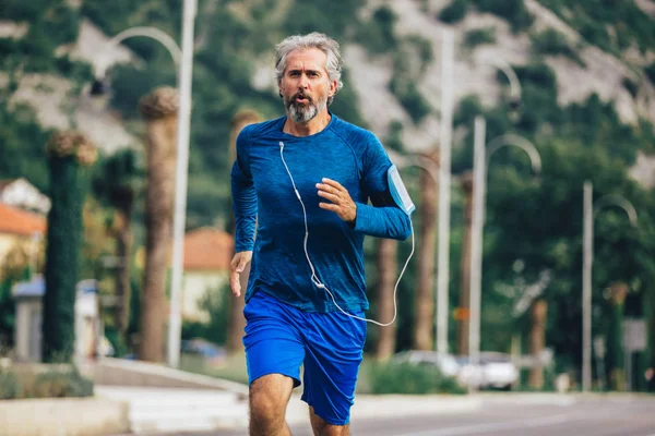 Aktywny starszy mężczyzna jogging w słoneczny dzień — Zdjęcie stockowe