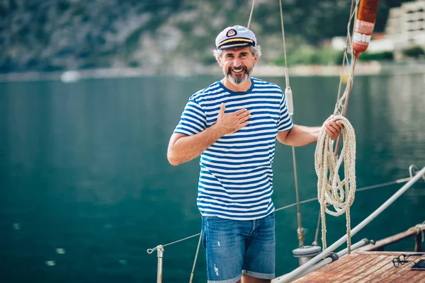Porträt eines älteren Mannes, der Knoten knüpft und einen Liegeplatz für sein Boot sichert — Stockfoto