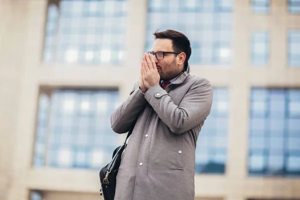 Young businessman standing in front of huge modern business buil — Stock Photo, Image