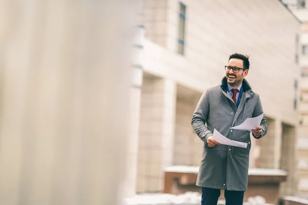 Young attractive businessman holding documents, papers. Young co — Stock Photo, Image