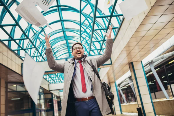 Business man celebrating by throwing papers in the air — Stock Photo, Image