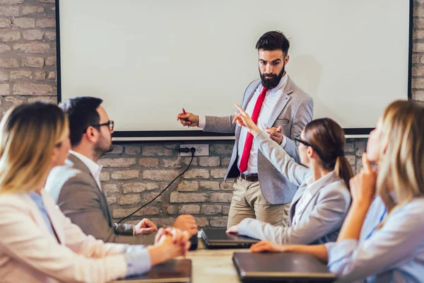 Confident speaker giving public presentation using projector in