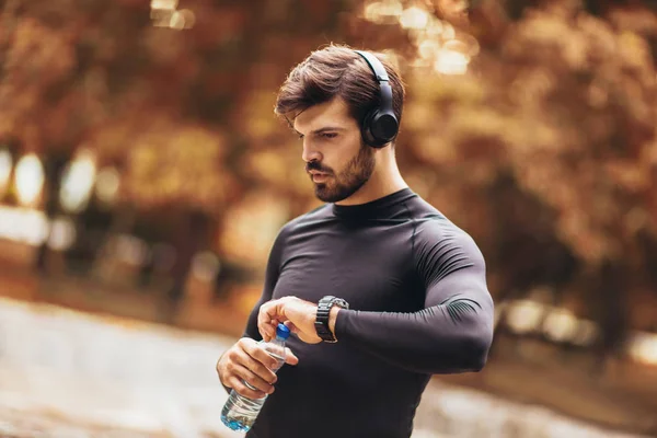 Portret van een jongeman op een ochtend joggen in het herfstpark, — Stockfoto