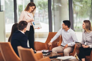 İş ekibi yeni proje üzerinde çalışıyor ve gülümsüyor. Erkek ve kadın 