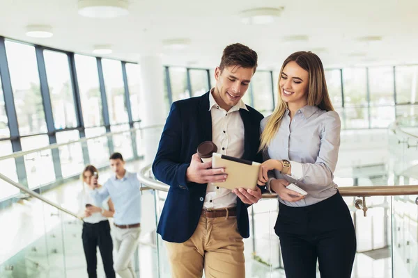 Hermosa mujer de negocios y hombre sosteniendo una tableta en sus manos — Foto de Stock