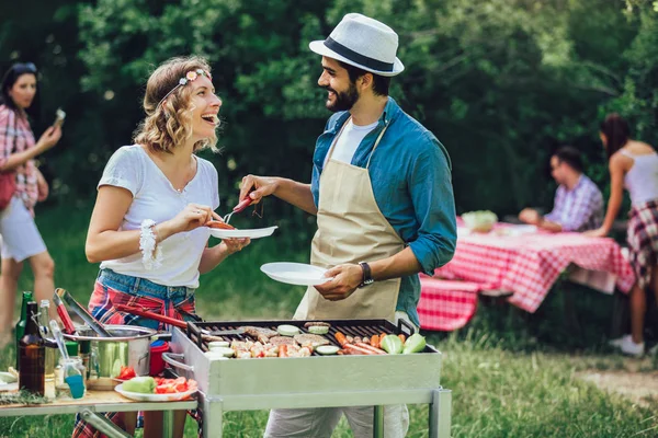 Jonge vrienden met plezier grillen vlees genieten van barbecuefeest. — Stockfoto