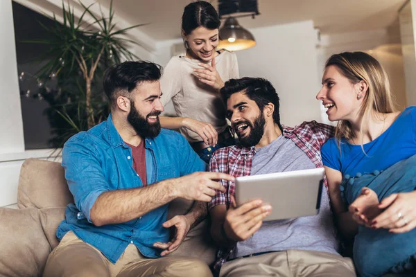 Cuatro amigos felices riendo viendo contenido de los medios juntos en un — Foto de Stock