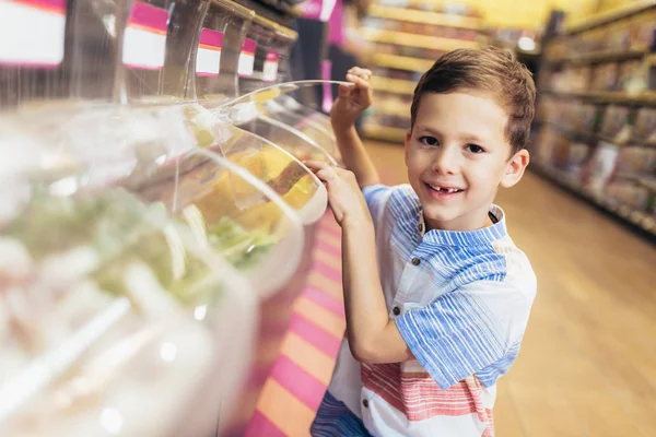 Chico mirando dulces en un escaparate en un centro comercial — Foto de Stock