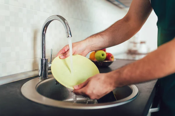 Homem lavar pratos sozinho na cozinha — Fotografia de Stock