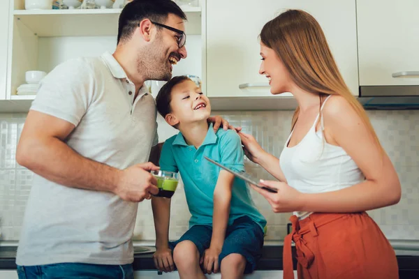 Modern family using a digital tablet while having breakfast in t — Stock Photo, Image