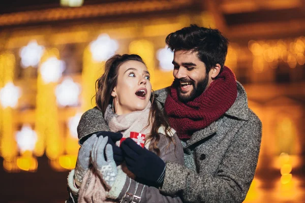 Ungt par i centrum med Holiday ' s Brights i bakgr — Stockfoto