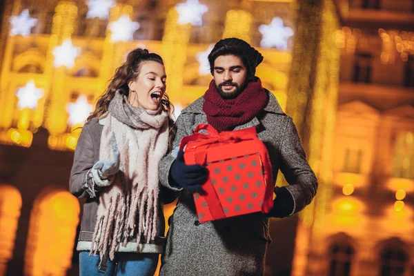 Jong stel in het centrum met vakantie brights in backgr — Stockfoto