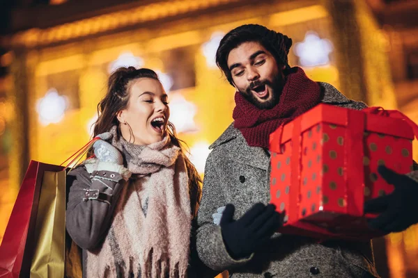 Young couple in the city centre with holiday's brights in backgr — Stock Photo, Image