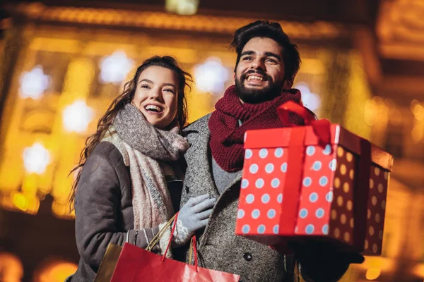 Jong stel in het centrum met vakantie brights in backgr — Stockfoto