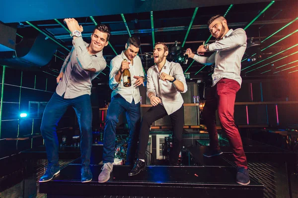 Groep van lachende mannelijke vrienden hebben plezier in nachtclub — Stockfoto