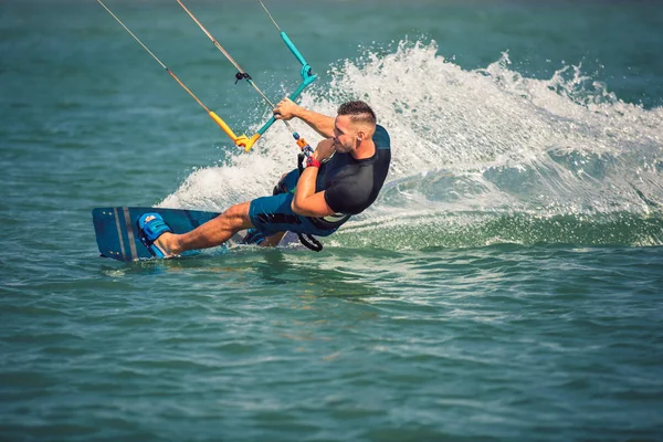 Professionele kiter maakt de moeilijke truc op een rivier. KITESUR — Stockfoto