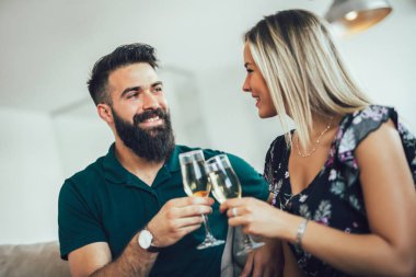 Güzel genç çift bardak şampanya ve smili tutuyor