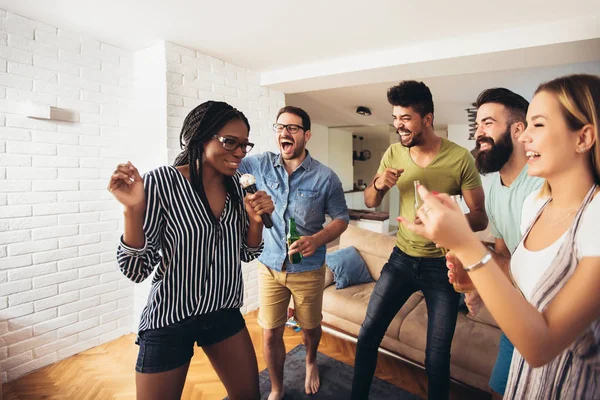 Happy friends singing together at home. Karaoke party concept — Stock Photo, Image