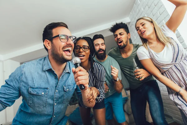 Happy vrienden thuis samenzang. Karaoke party concept — Stockfoto