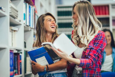 Öğrenciler kütüphanede okuyor. Gençler vakit geçiriyor.