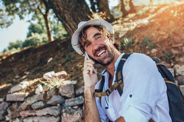 Modieuze man toerist met behulp van telefoon in het bos. — Stockfoto