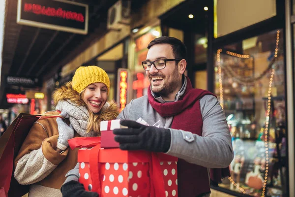 若いカップルが街でクリスマスショッピングをしている — ストック写真