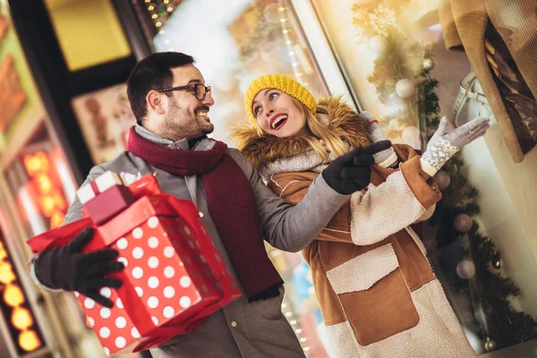 Janela de casal jovem compras em um dia de inverno, à procura de um Chri — Fotografia de Stock