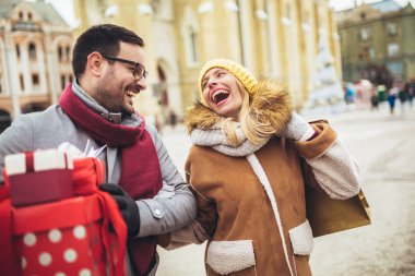 Genç çift şehirde Noel alışverişi yapıyor.