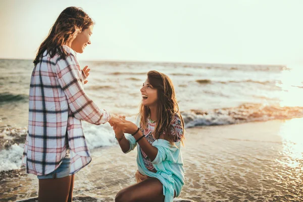 Mulher propondo a sua namorada feliz na praia — Fotografia de Stock