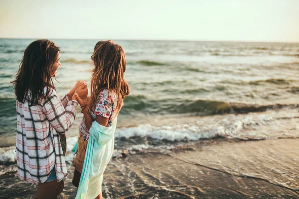 Chica bonita se divierte con su novia en la playa — Foto de Stock