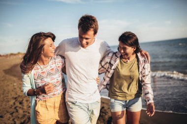 Sahilde yürüyüş eden genç arkadaşlar. Gençler arıyor h