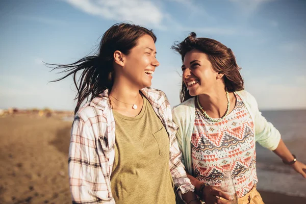 漂亮女孩在沙滩上和她的女朋友玩得很开心 — 图库照片