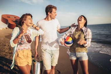  Gençler tatilde mutlu görünüyorlar. Beac 'a biniyorlar.