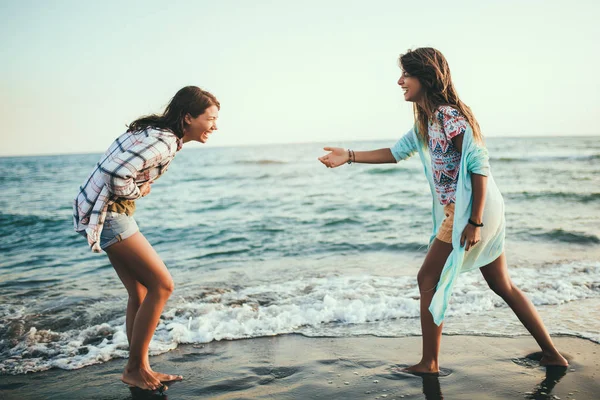 Chica bonita se divierte con su novia en la playa — Foto de Stock