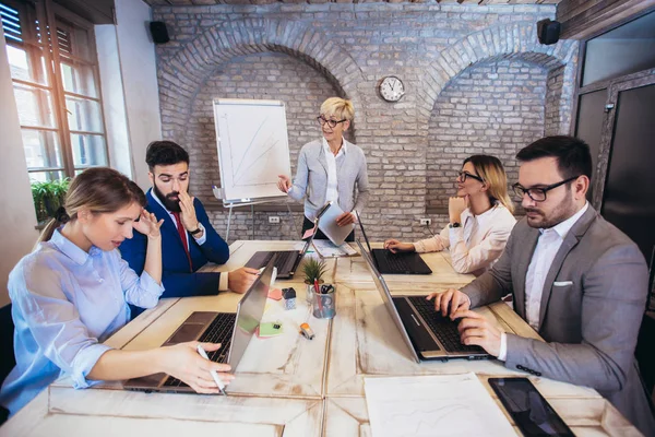 Senior zakenvrouw geeft presentatie aan zijn collega 's in van — Stockfoto