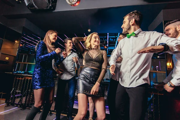Молодые люди танцуют в ночном клубе — стоковое фото